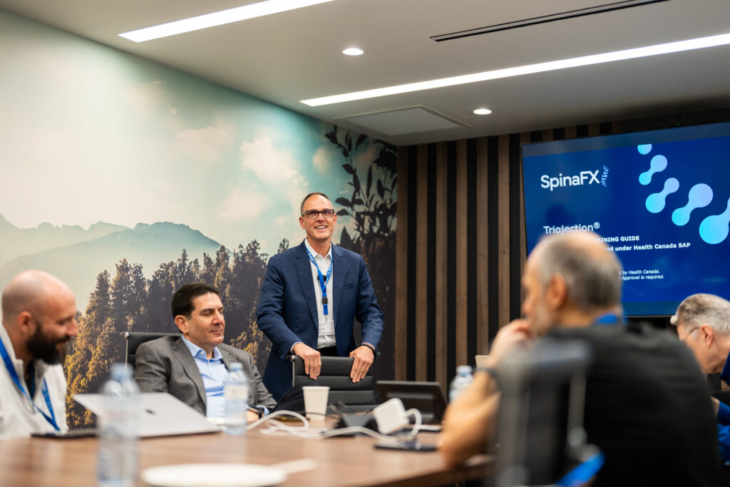 Medical professional delivering an engaging SpinaFX presentation to colleagues in a boardroom