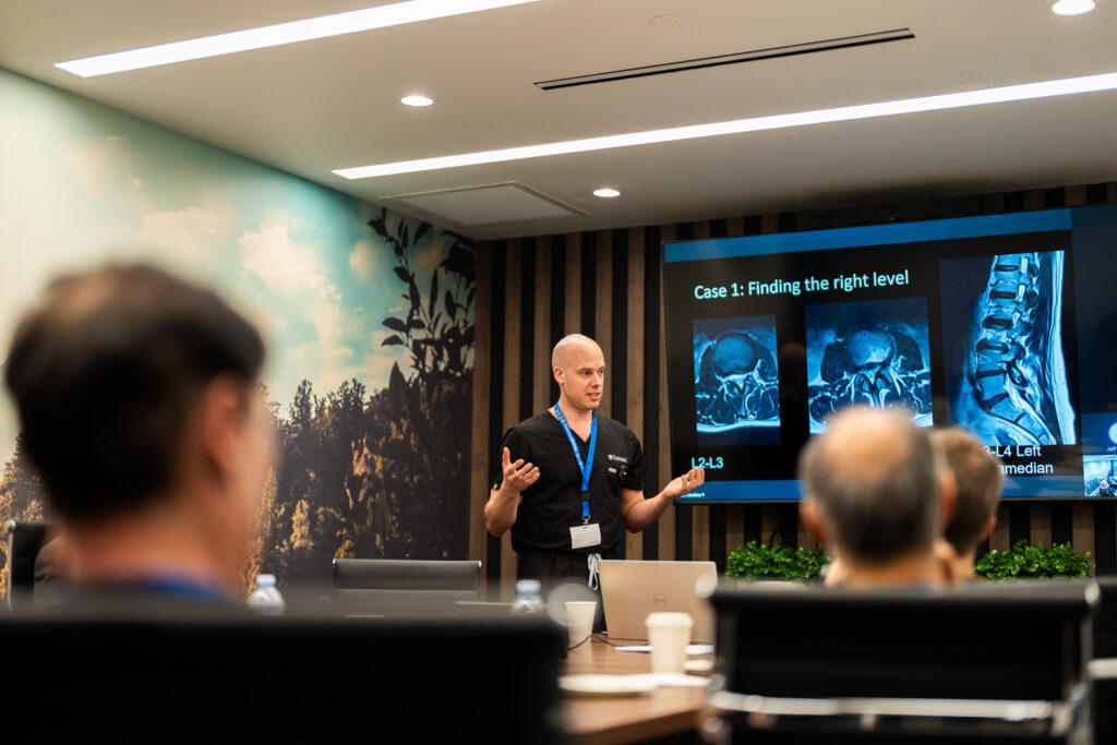 A medical professional of Spina FX giving a presentation on spinal imaging to a group of doctors
