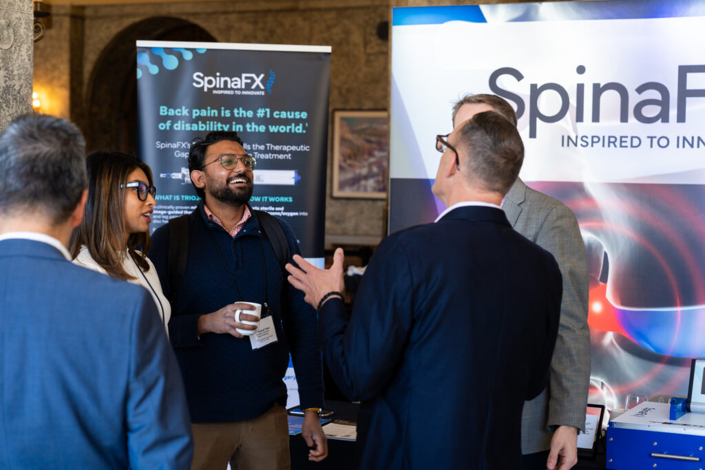 Group of professionals networking and discussing at the SpinaFX.com event booth